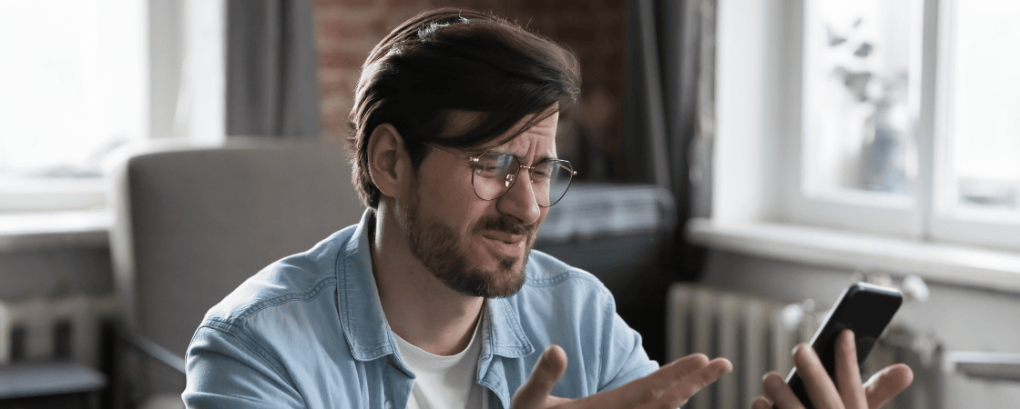 Frustrated user reading mobile phone with Actitech Limited charge billing issue